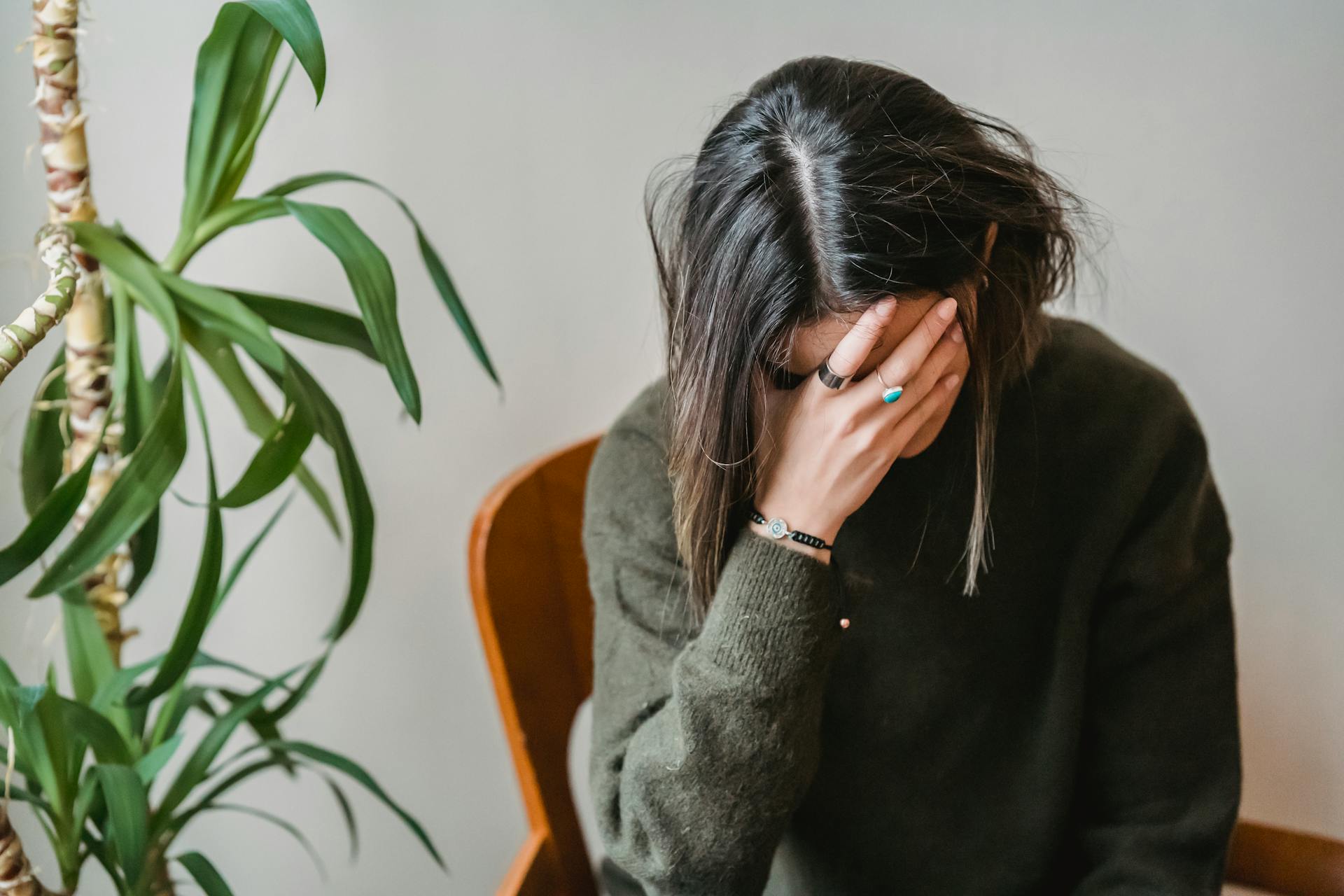 Woman with hands on her face looking overwhelmed and stressed while trying to make a decision, illustrating ADHD decision fatigue