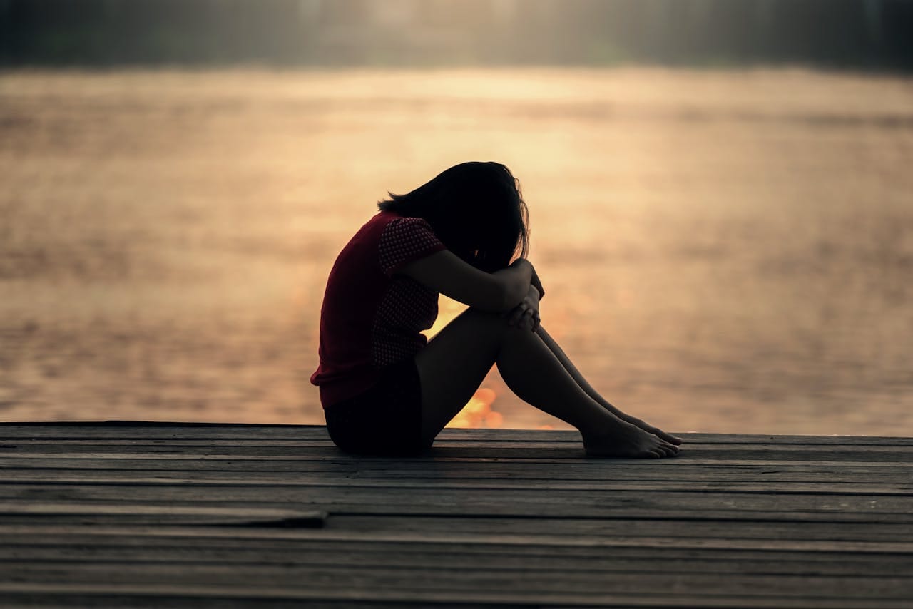 Woman coping with grief at Sea While Sitting on Beach