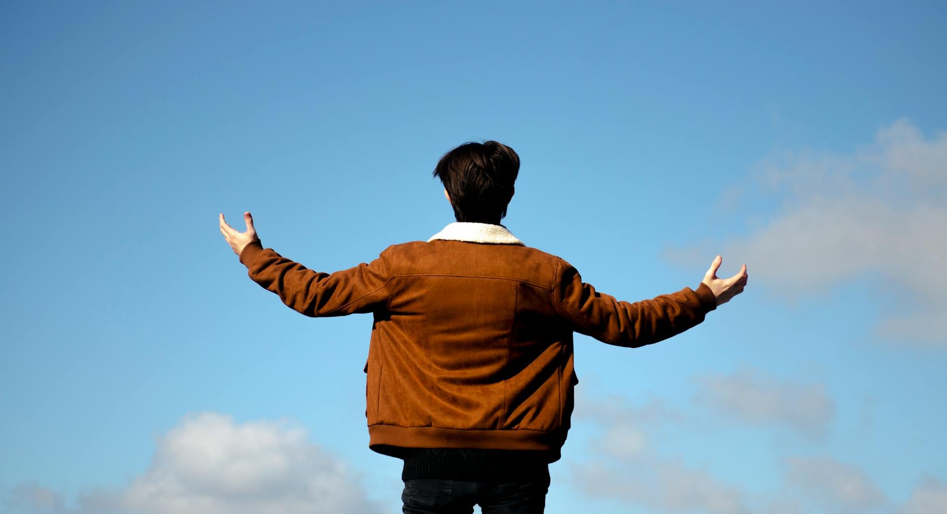 A man standing in front of an open sky showing radical acceptance and how to stop resisting reality