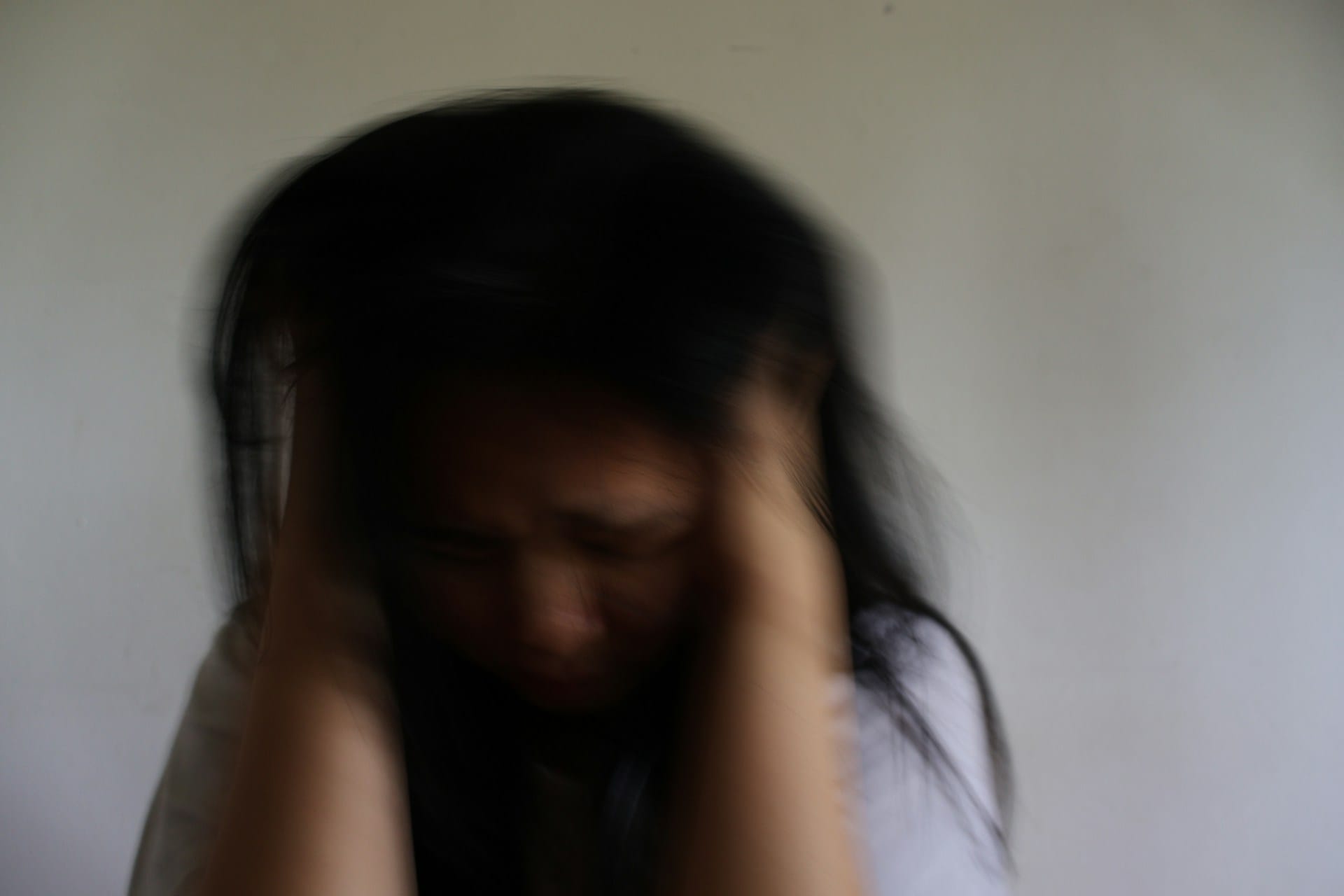 Woman sitting on a beach thinking about OCD and intrusive thoughts.